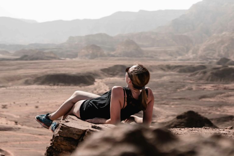 Traveler relaxing on a mountain top, symbolizing peace of mind achieved through Comprehensive Travel Insurance and Responsible Vacation Planning.