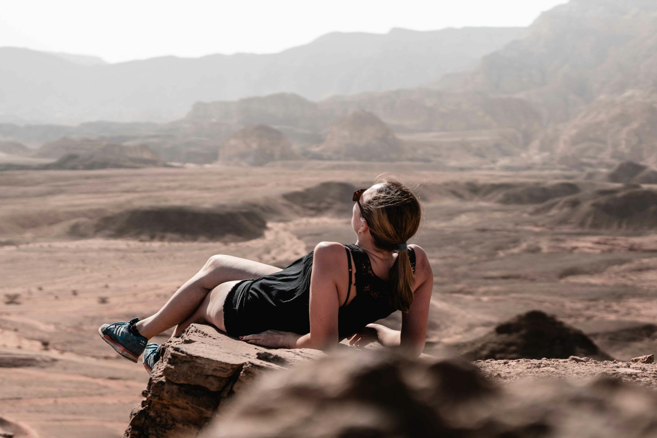Traveler relaxing on a mountain top, symbolizing peace of mind achieved through Comprehensive Travel Insurance and Responsible Vacation Planning.